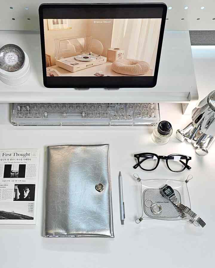 Modern home office with a clean desk featuring silver glossy book cover and transparent multi tray in harmonious tones