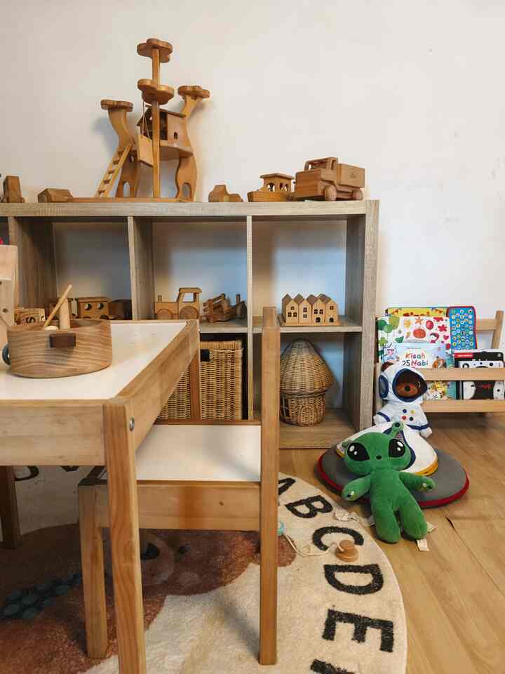 Natural wood-tone kids' room featuring a children's desk and chair with neatly arranged wooden toys creating a cozy atmosphere