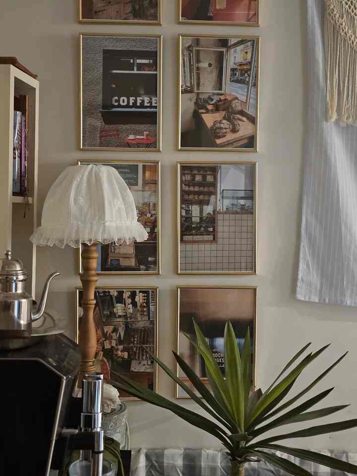 Beige toned room with wood-tone furniture and vintage picture frames in a cozy home cafe and dining space