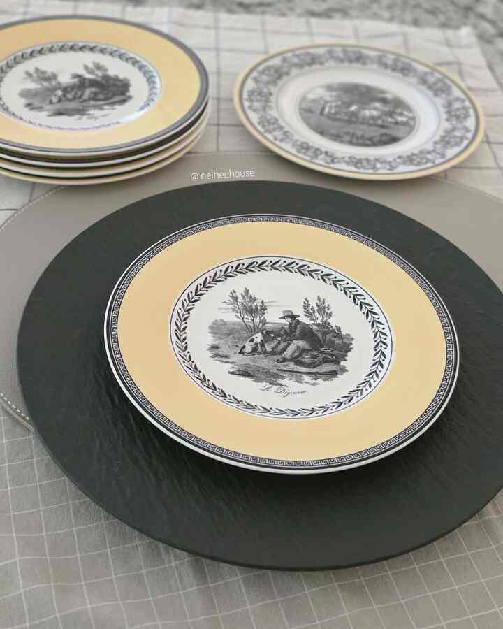 Table setting with yellow and black plates arranged on a checkered tablecloth, showcasing elegant decorative dishware