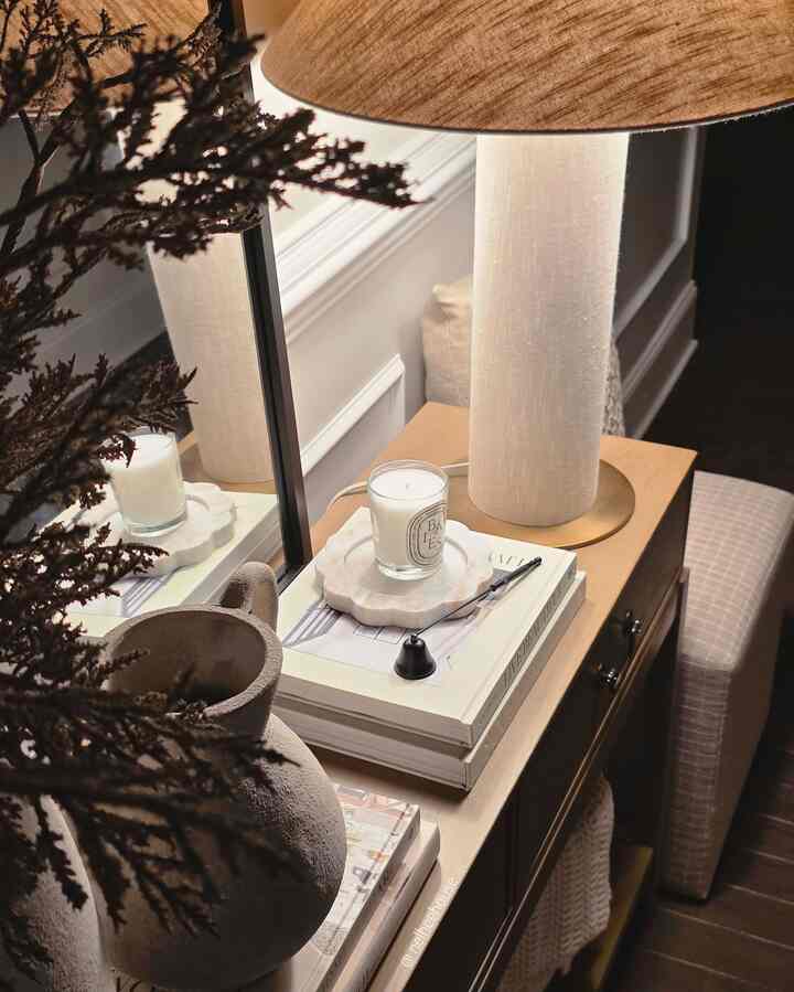Beige-toned entrance space featuring a console table with table lamp and candle creating a cozy atmosphere