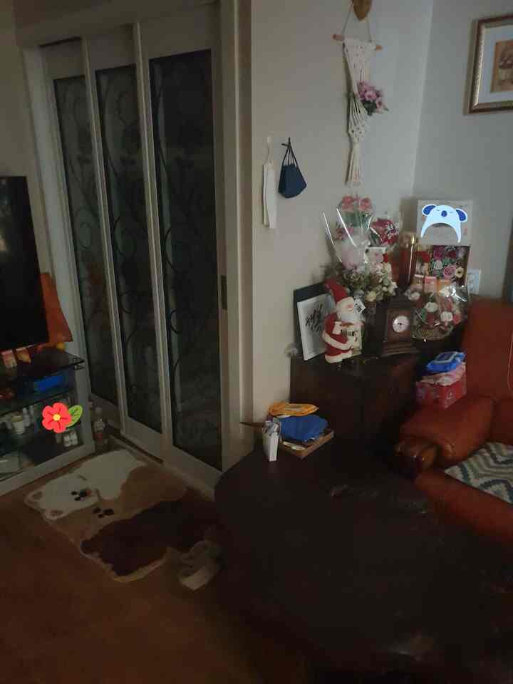 ブラウンとオレンジの色調のリビング、くまのラグとオレンジのソファ、ダークブラウンのコーヒーテーブルが配置された温かみのある空間