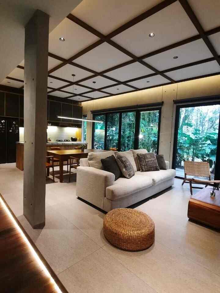 Natural brown and beige toned living room featuring sofa, coffee table, and wooden dining table in a cozy setting