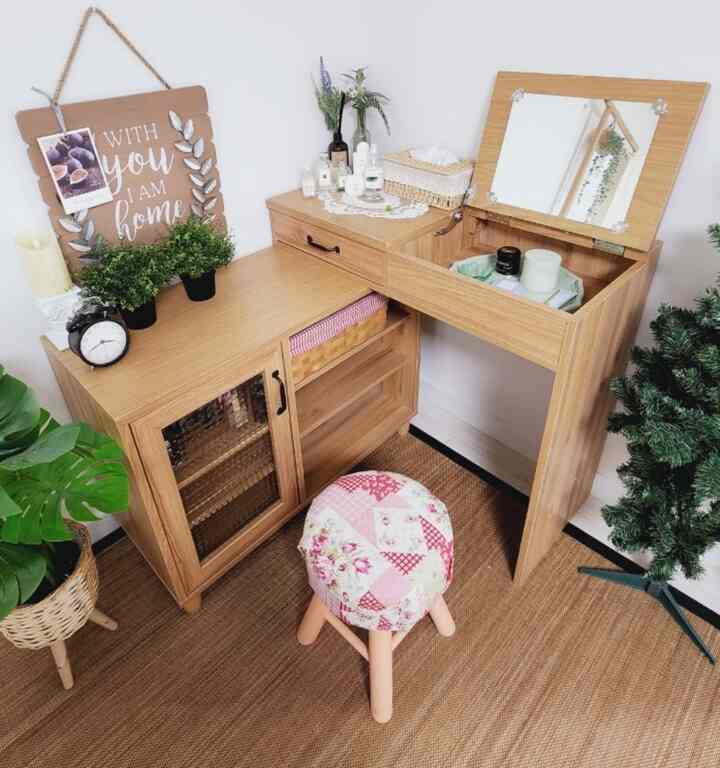 ナチュラルウッドトーンとベージュカーペットが調和したウォークインクローゼットの化粧台と花柄スツールのある印象的な空間