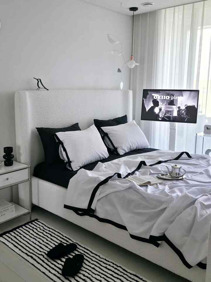 White and black bedroom featuring large bed and modern design elements with a clean aesthetic