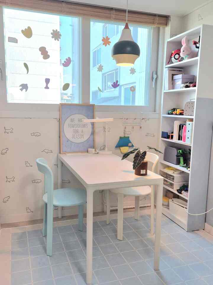 ブルーとホワイトの色調の子供部屋、机と収納が配置されたシンプルで居心地の良いインテリア