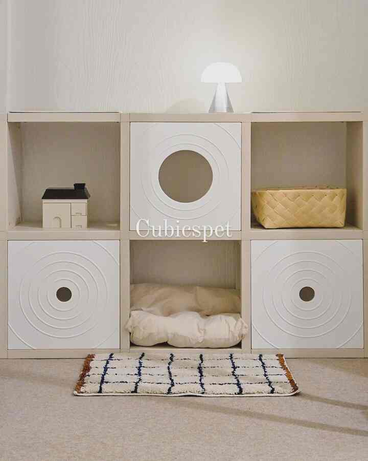 Bright natural-toned modular bookshelf cat tower with storage elements in a clean pet-friendly space