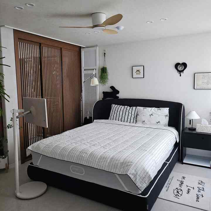 ホワイトとブラック、木目調が調和したモダンでシンプルな寝室の印象的な空間