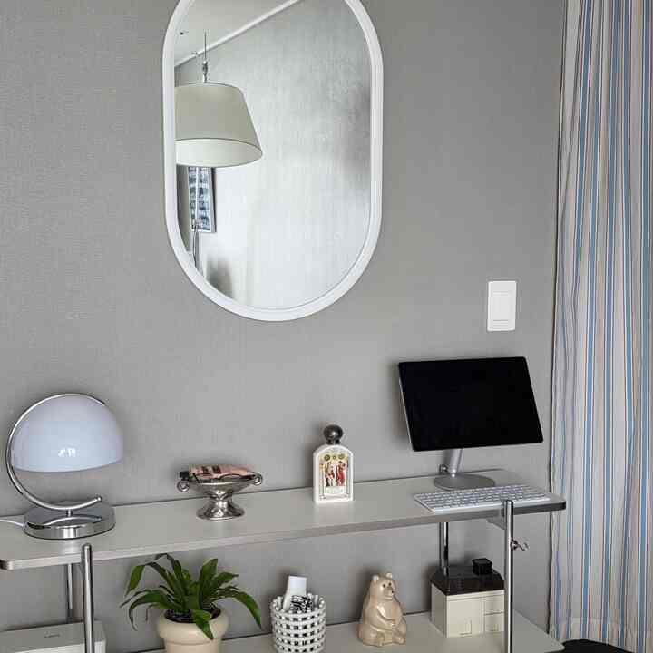 Natural color entrance space featuring a 3-tier shelf, Mid-Century Modern lamp, and striped curtain in a clean setting