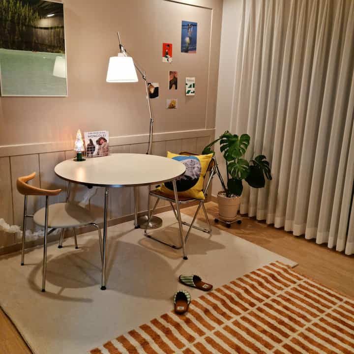 Warm natural tone dining room featuring a round table, floor lamp, and cozy accents