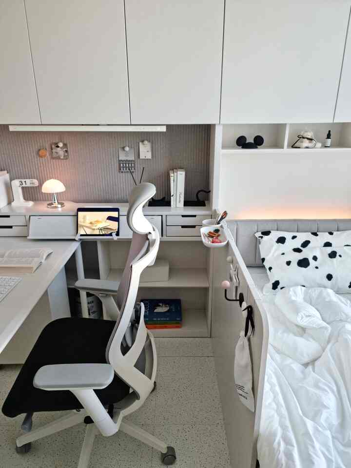 白とグレーの色調の子供部屋、イルムデスクと快適な椅子が配置された整頓された空間