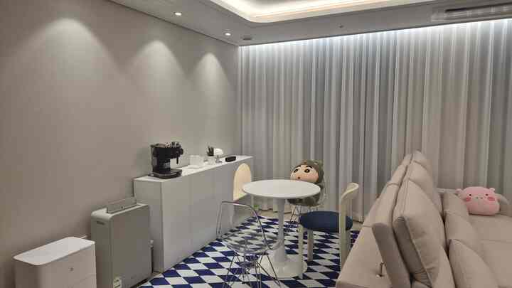 白を基調としたリビング、シンプルモダンなソファと丸いダイニングチェアが配置された雰囲気のある空間