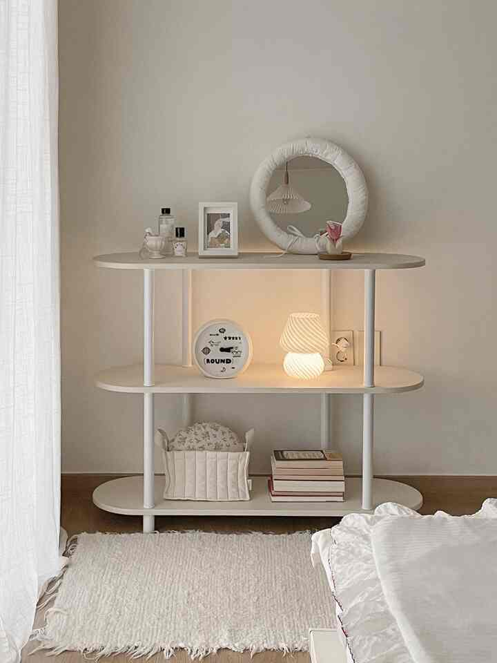 ナチュラルカラーとモノトーンのリビングの一角に、モノラウンドの3段収納棚が配置されたシンプルで落ち着いたインテリア