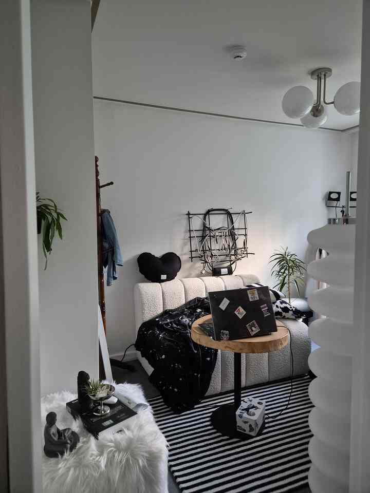 White and black toned living room featuring textured sofa, wooden coffee table, striped rug with simple modern ambiance