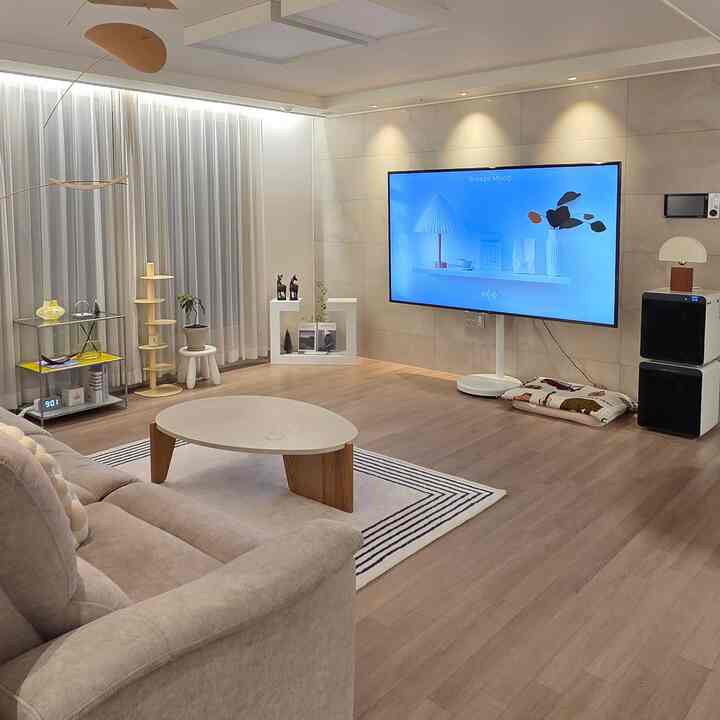 暖かいベージュ調のリビング、居心地の良いファブリックソファと低めの円形テーブルが配置された雰囲気のあるインテリア