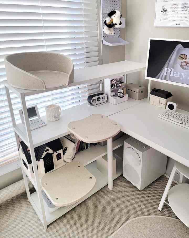 White and natural-toned home office featuring a desk with cat house and bed, creating a cozy workspace