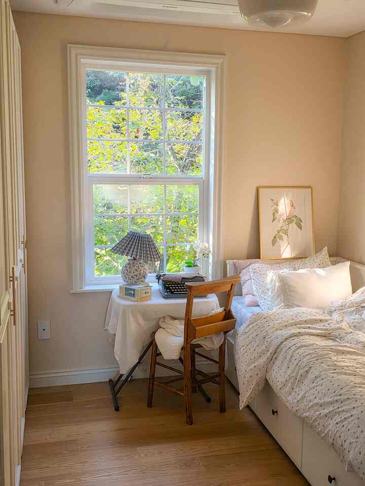 温かみのある木目調と白が調和したコンパクトな寝室、窓辺に置かれた机と椅子で読書に最適な雰囲気
