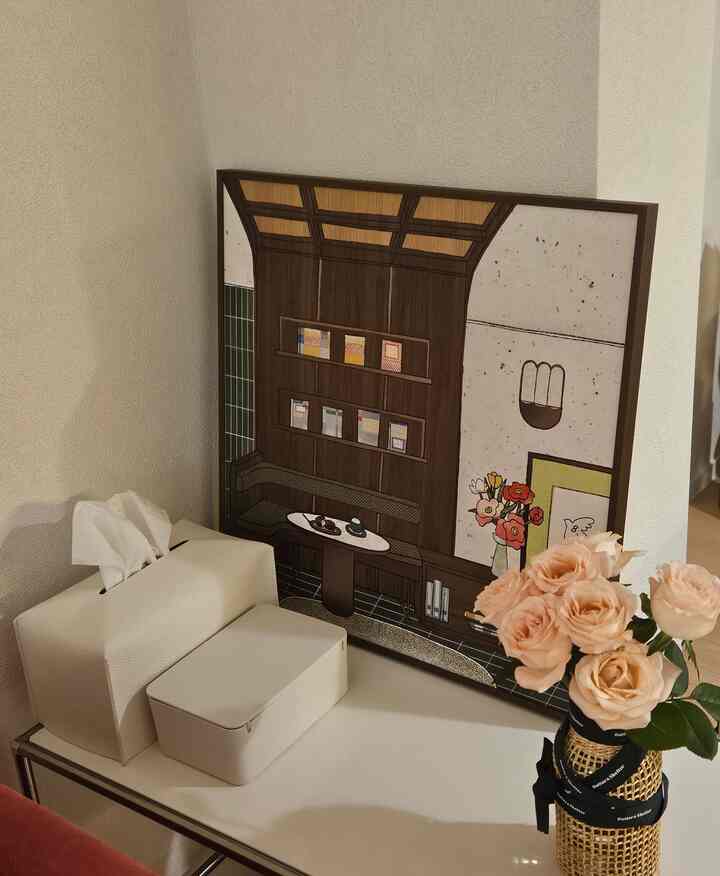 ベージュと白の色調のテーブル上にティッシュケースと花瓶が置かれた落ち着いた空間