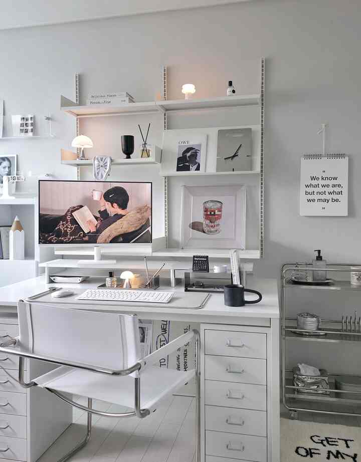 Bright white-toned home office space featuring mid-century modern desk and armchair, with a transparent crystal frame artwork creating a clean interior