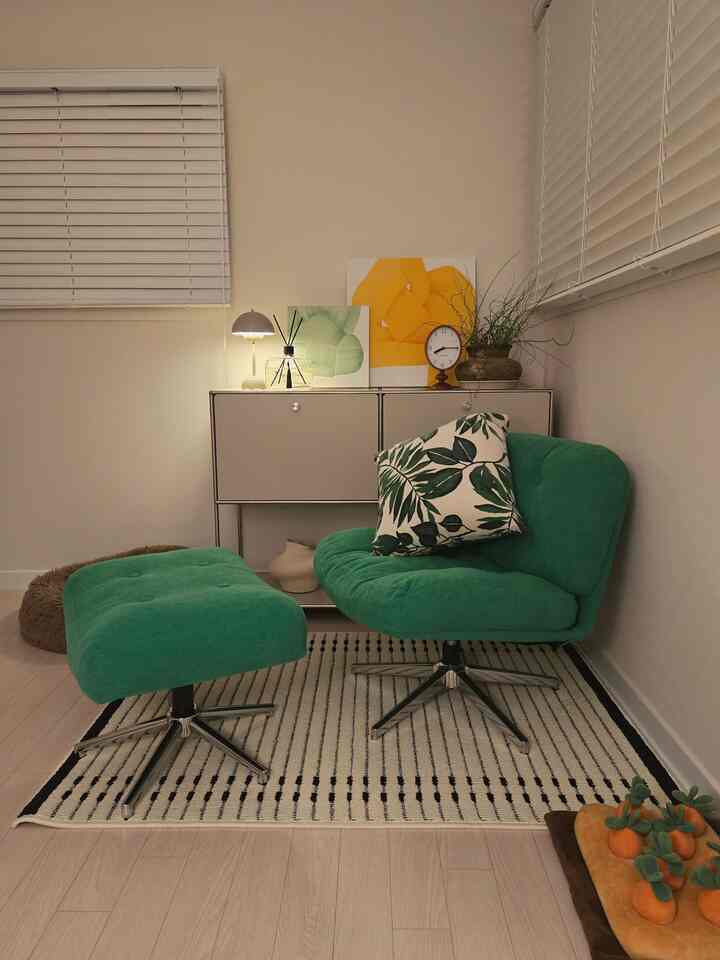 モノトーンのベージュの壁と黒のストライプラグがあるモダンな書斎、緑のアームチェアとスツール、サイドテーブルが配された落ち着いた空間