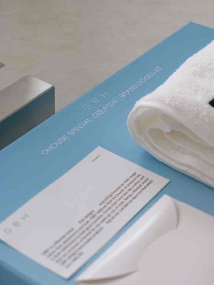 青い表面の上に白いタオルとシルバーのステンレス製ティッシュケースが配置された清潔感のあるインテリアアイテムの写真