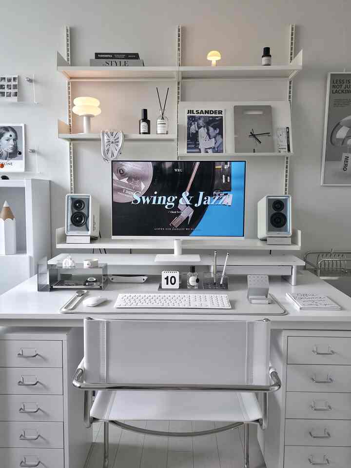 White-toned home office featuring a modern desk and monitor stand creating a clean and minimalist workspace