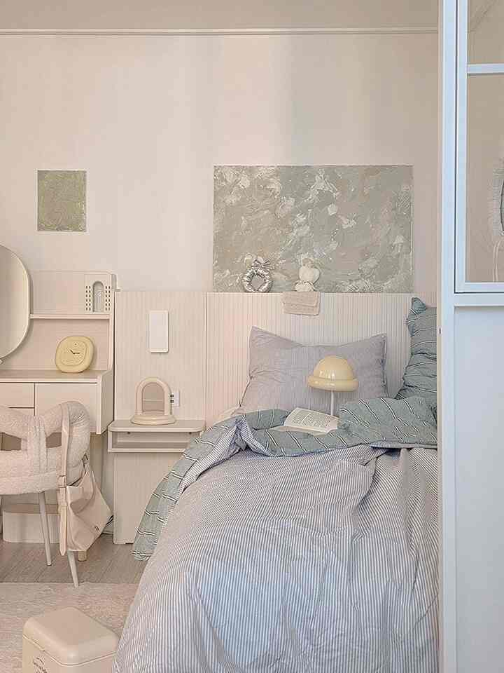 Bright white and mint-tone bedroom featuring striped bedding and simple furniture in a natural Scandinavian style