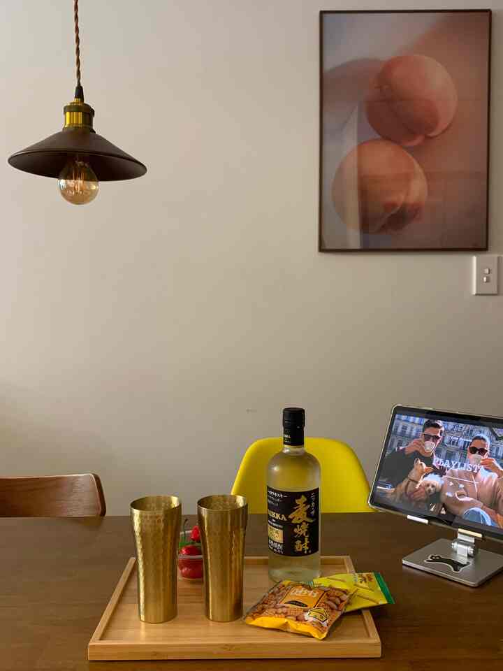 木目調と黄色が調和したダイニングテーブルと椅子、ミッドセンチュリーモダン風のペンダントライトが配置された温かみのあるおうちカフェのインテリア