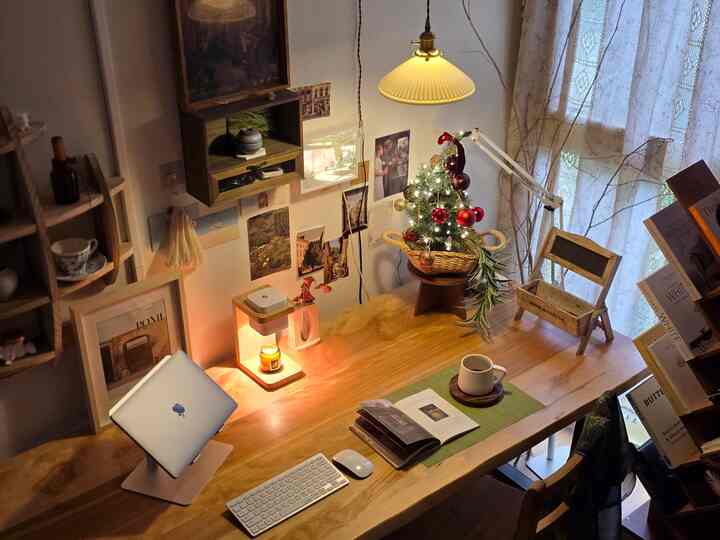 暖かい木目調の寝室横ワークスペース、ウッドスラブテーブルとミニクリスマスツリー、キャンドルウォーマーが配置された居心地の良い落ち着いた雰囲気のインテリア