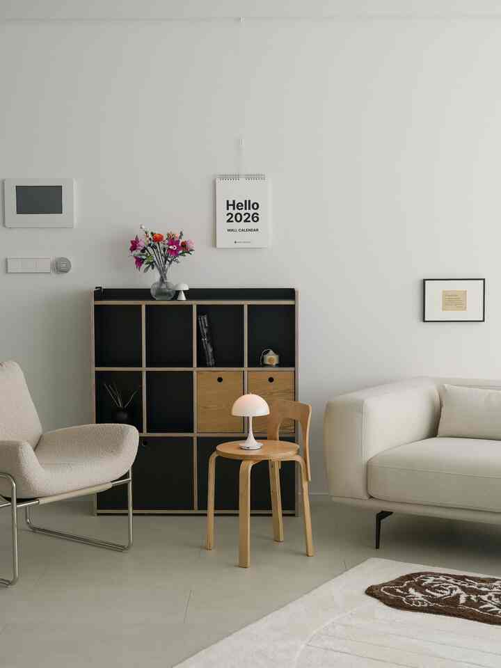 ベージュ調のリビング、モダンな家具と黒の収納が配置された印象的で落ち着いたインテリア