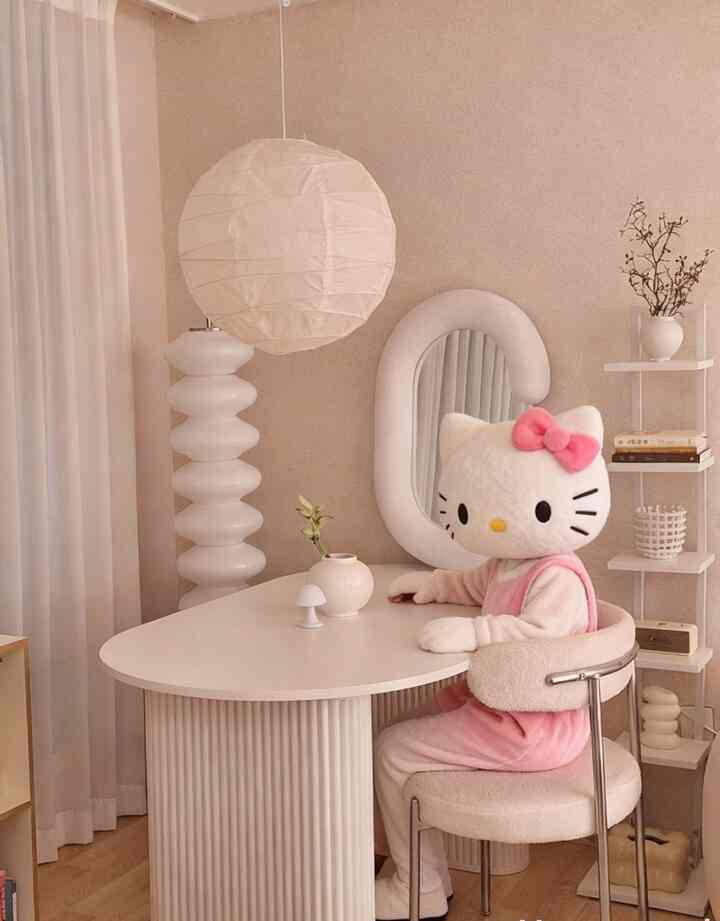白とベージュ調のリビング、曲線的な家具とキティのぬいぐるみが置かれた雰囲気のある空間