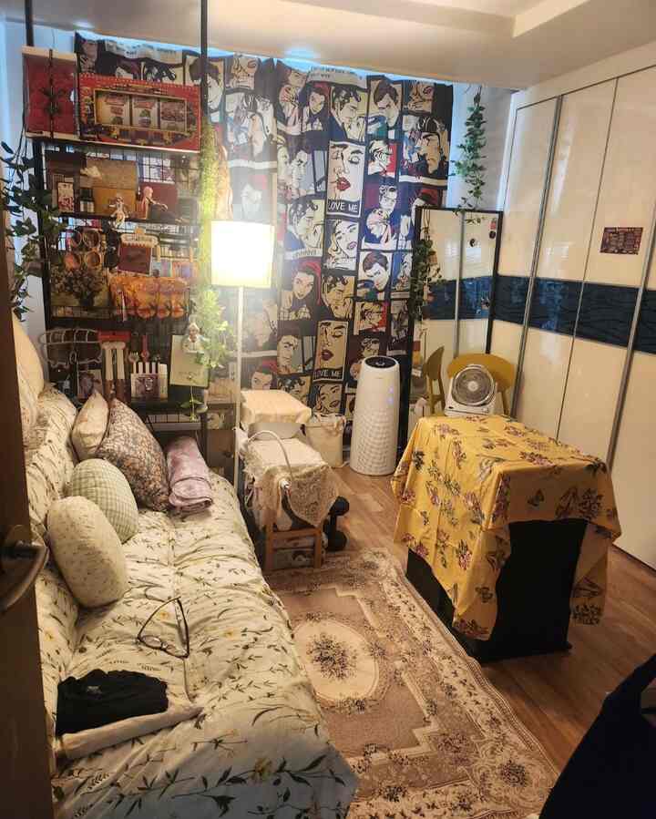 黄色と茶色のトーンが特徴の小さなリビング、花柄のソファとフロアランプが配置された雰囲気のある空間