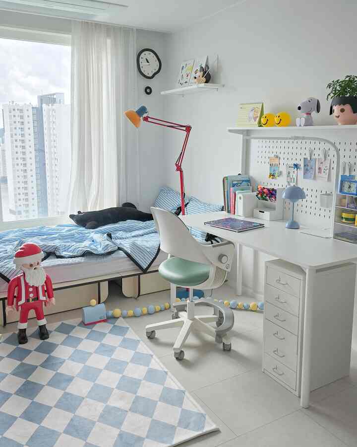 白と青の色調の子供部屋、机とシングルベッド、子供用チェアが配置された清潔感のある居心地の良いインテリア