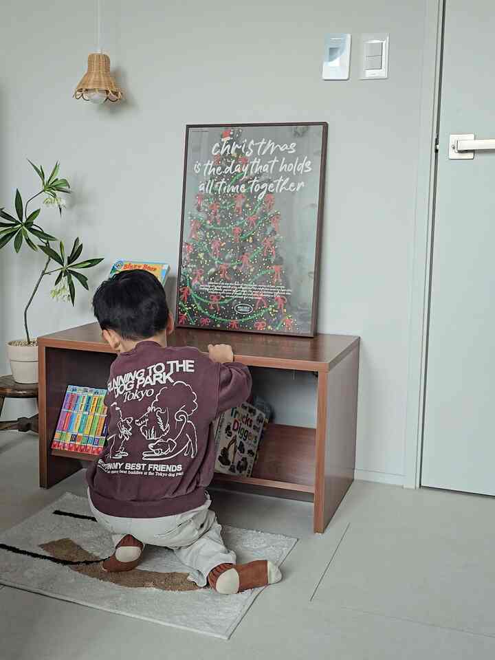 ナチュラルカラーのリビング、子供と本棚が配置された雰囲気のあるインテリア