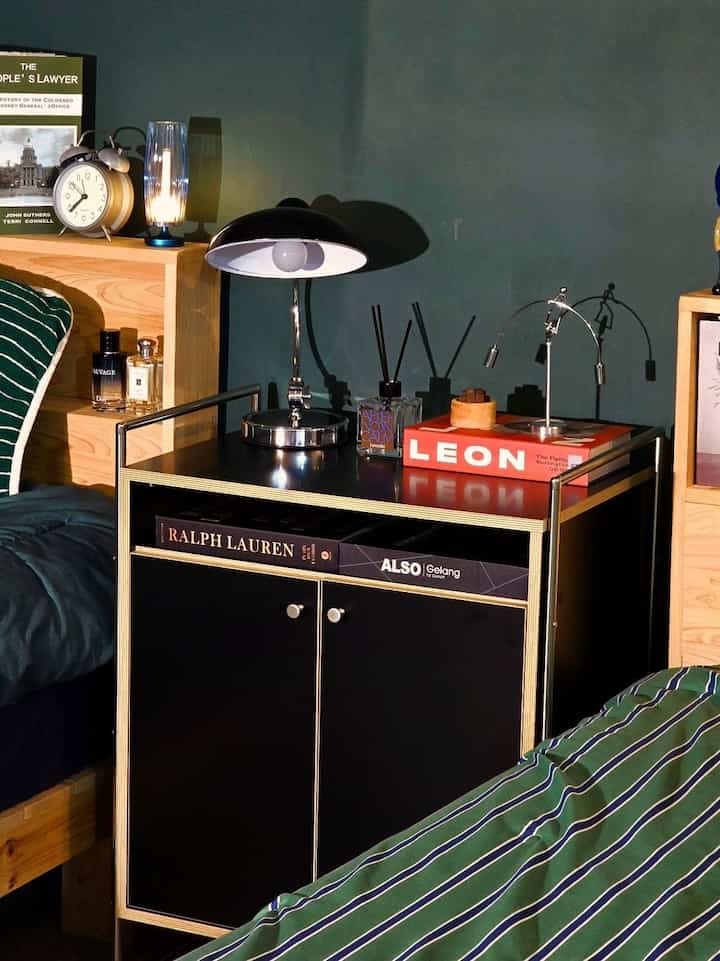 Natural wood-tone bedroom featuring black nightstand and modern table lamp in a cozy setting