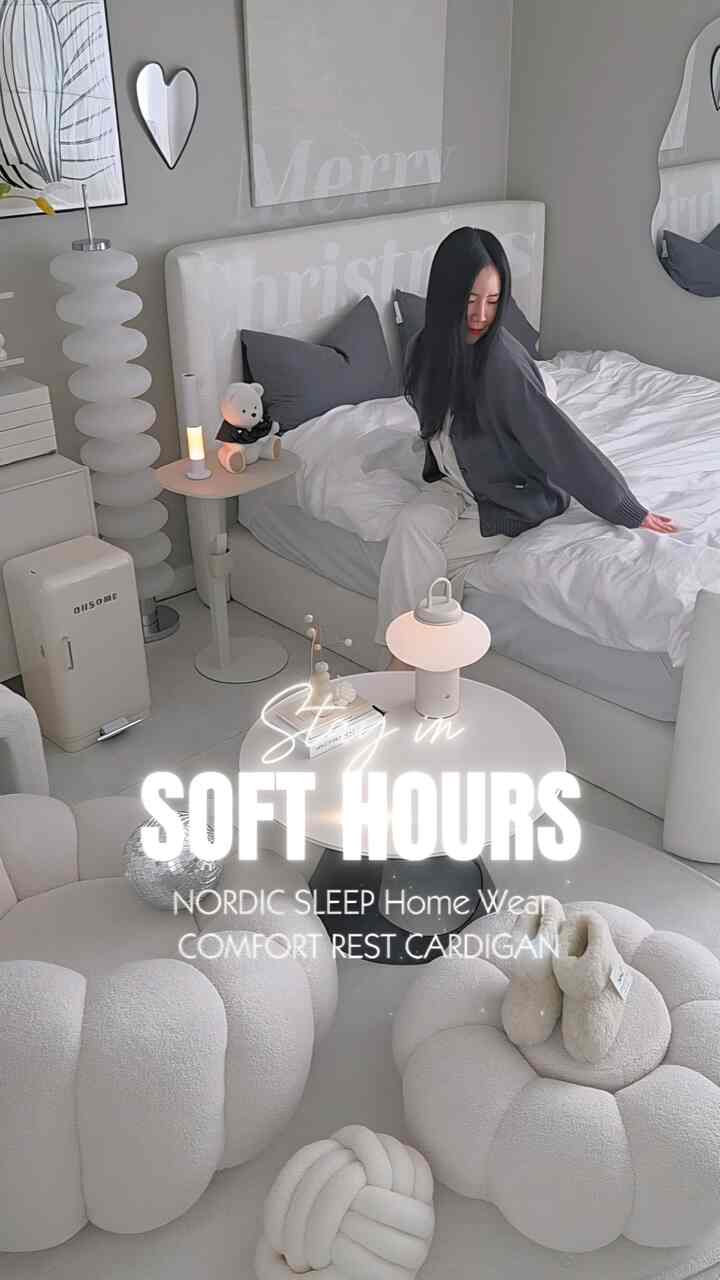 アイボリーとネイビーのトーンが特徴的な寝室、ファブリック製のベッドとモダンなサイドテーブルが配置された落ち着いた雰囲気のインテリア