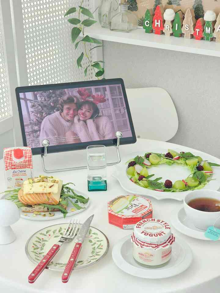 明るいホワイトトーンのホームカフェ空間、ダイニングテーブルに多彩な皿とお茶、新鮮な食材が配置されたモダンな雰囲気のインテリア