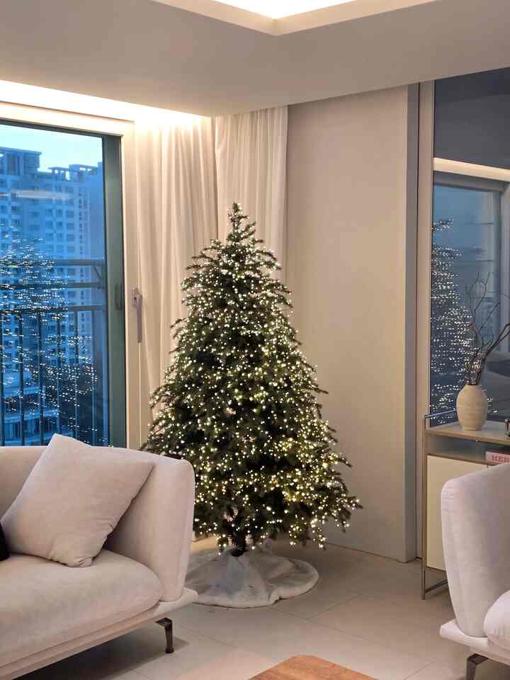 白を基調としたリビング、クリスマスツリーとイルミネーションが配置されたモダンで印象的な空間