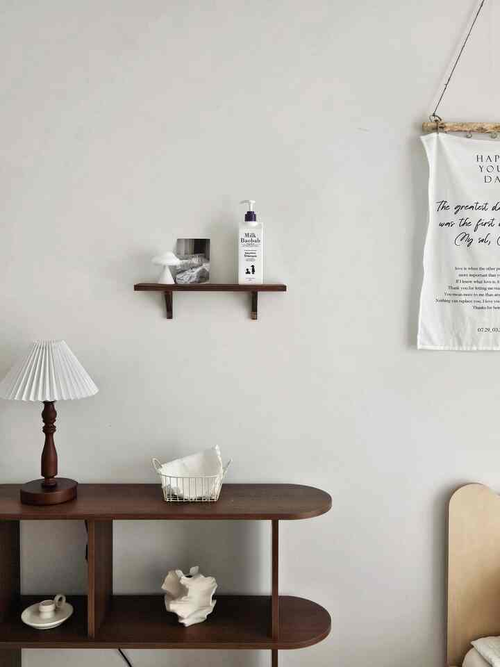 ナチュラルな色調の子供部屋、ウォールナットの木製家具と壁棚、ムードランプが配置されたシンプルで温かみのあるインテリア