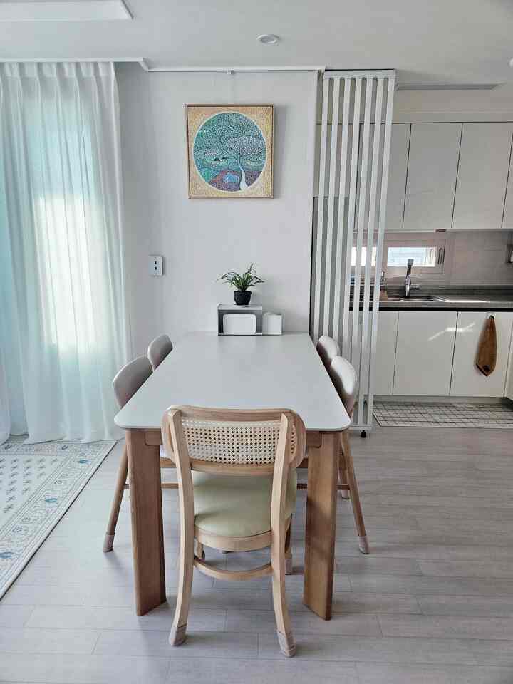 白と木目調のダイニング、自然な雰囲気のテーブルと椅子が配置された落ち着いた空間
