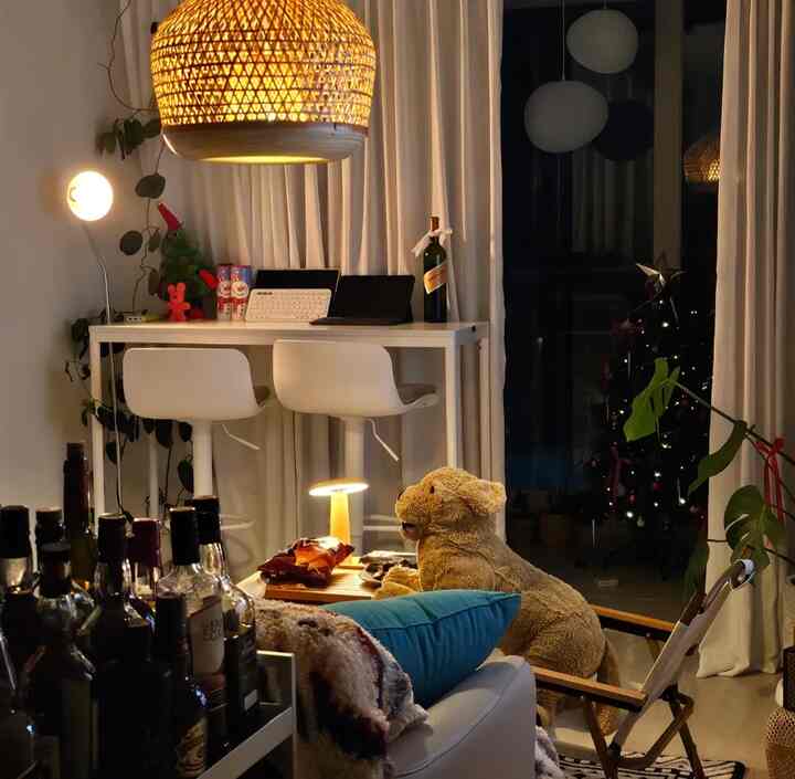 暖かいベージュとホワイトトーンのリビングルーム、バー テーブルとキャンピングチェアが配置された雰囲気のある空間