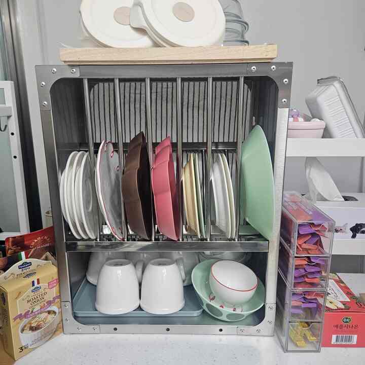 シルバーの金属製キッチンラックに様々な皿やカップが整頓されたキッチンスペース