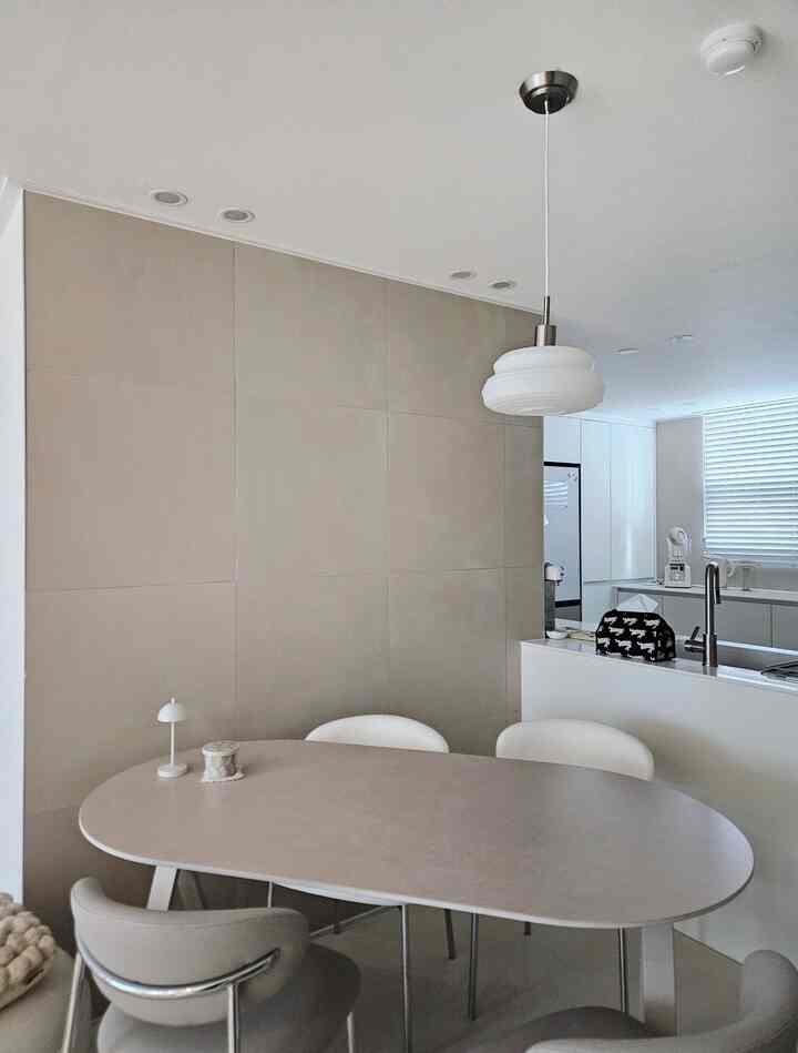 白とベージュのトーンが調和したダイニング、モダンなテーブルと椅子が配置された落ち着いた印象的な空間