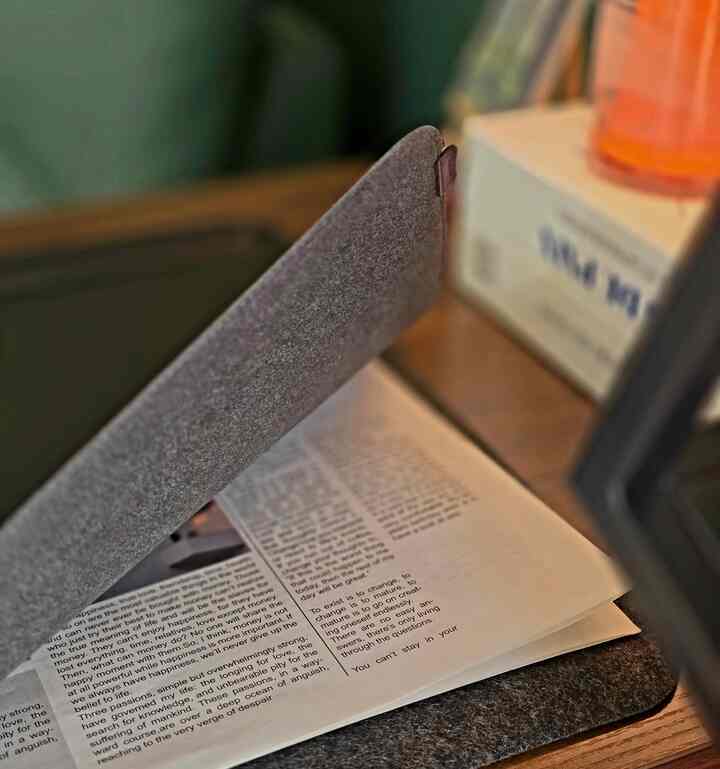 グレーのテーブルマットと開いた本が置かれた自然な雰囲気のデスクスペース