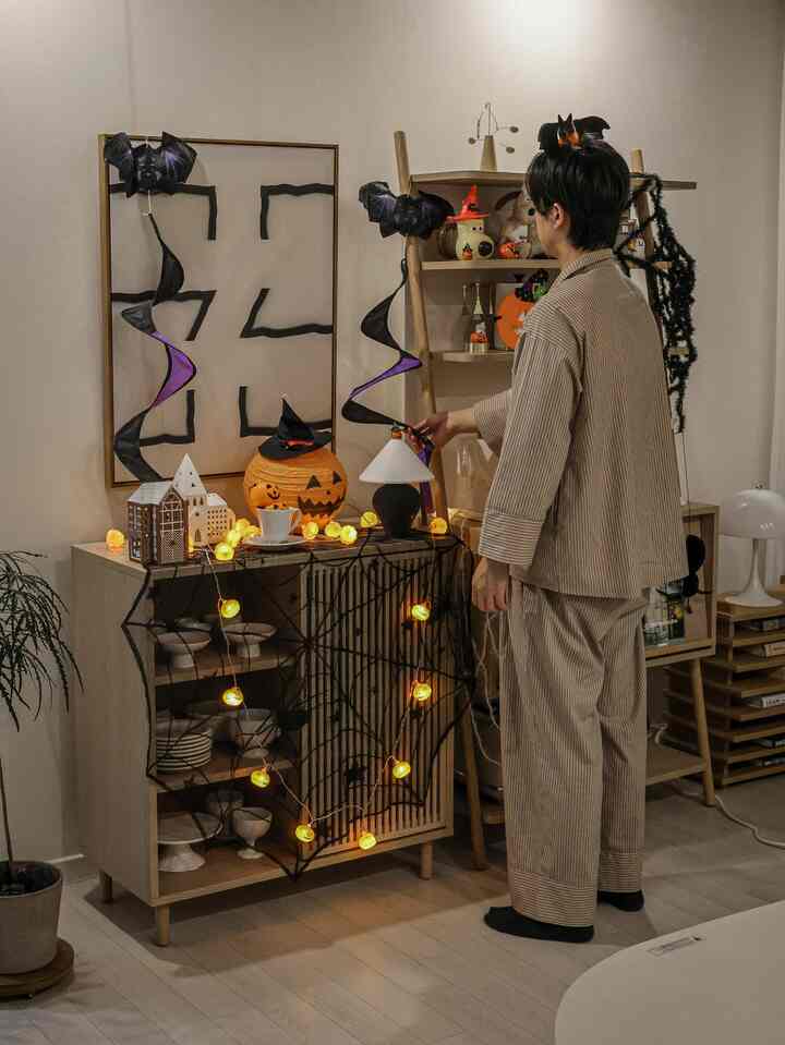 ナチュラルなトーンのリビング、ハロウィン装飾と照明が配置された雰囲気のある空間