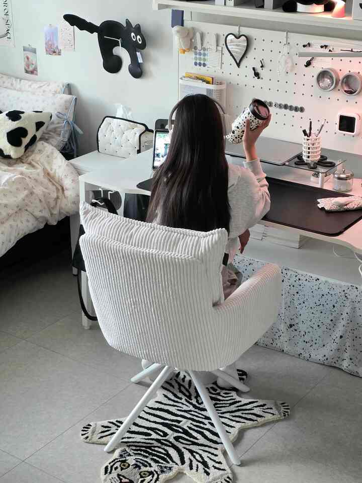 White and black tone small bedroom home office featuring desk and cozy chair with functional, tidy atmosphere