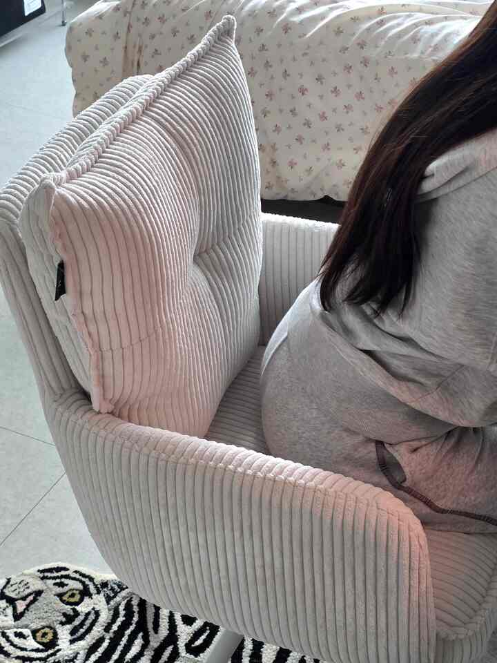 Cozy living room featuring cream corduroy armchair and large animal print carpet with black and white tones