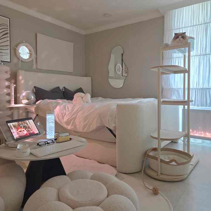 落ち着いたホワイトとナチュラルカラーの寝室、キャットタワーと居心地の良い家具が配置された雰囲気のあるインテリア