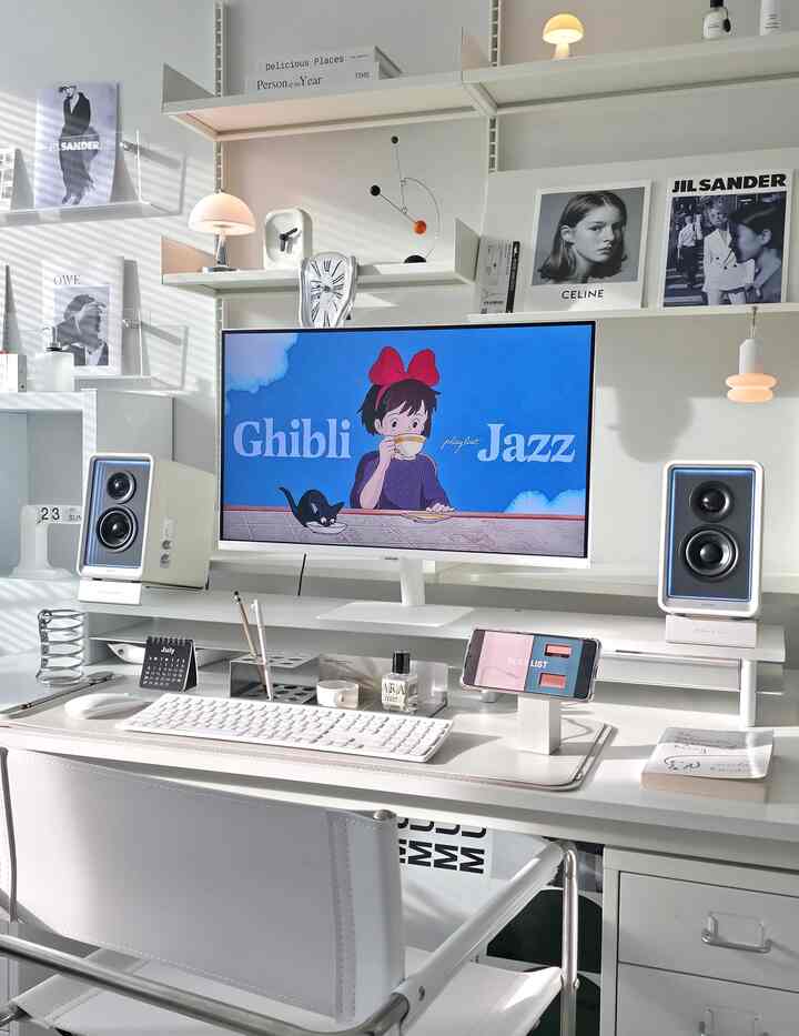 ホワイトトーンのホームオフィス、透明なアクリル棚とミッドセンチュリーモダンの装飾が配置された整頓された作業空間