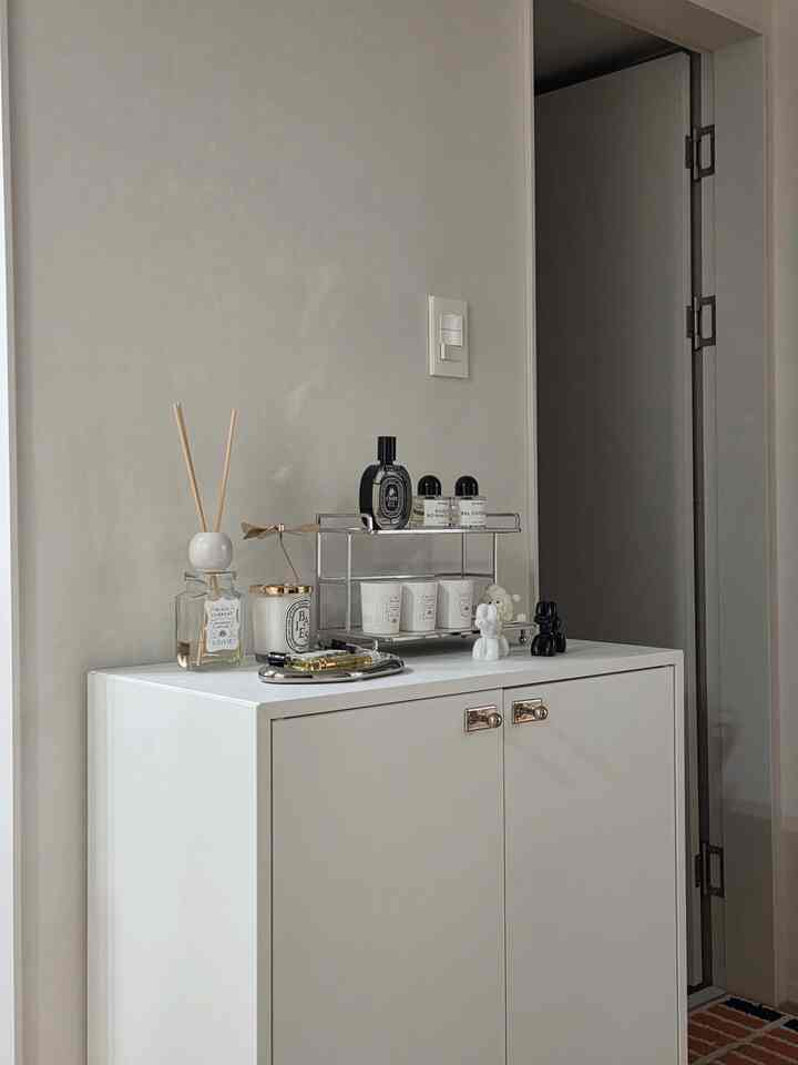 白を基調とした玄関、すっきりとした収納キャビネットが配置されたミニマルでモダンなインテリア